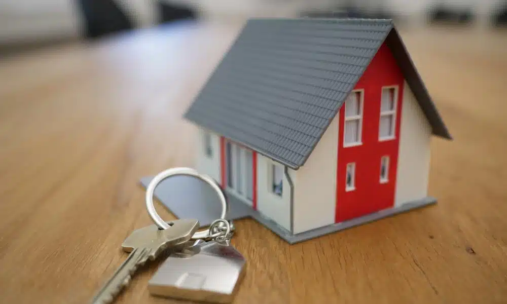 white and red wooden house miniature on brown table